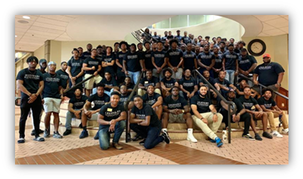 Large group of men sitting and standing on stairs of the student center.