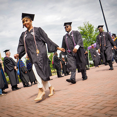 graduates walking down a path